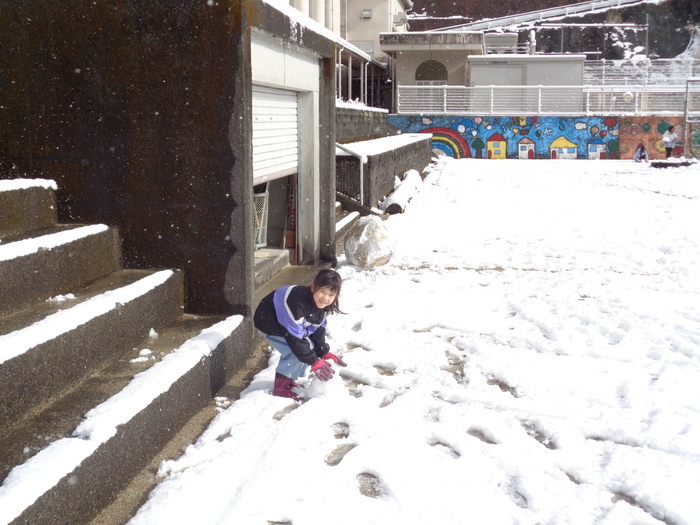 雪玉を作る児童